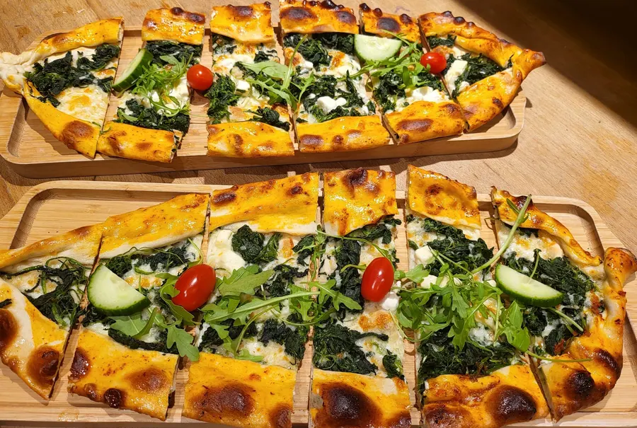 Zwei Pide mit Spinat und Käse auf Holzbrettern