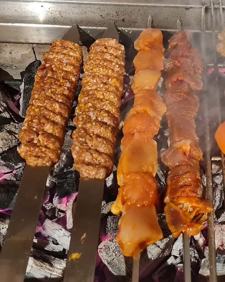 Adana, Hähnchenspieß und Lammspieß nebeneinander über der Holzkohle